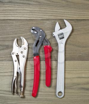 Vertical photo of assortment of used commercial wrenches on aged wood  