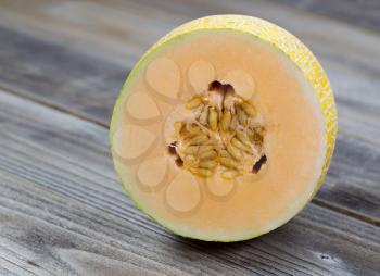 Closeup view of a freshly cut half melon on rustic wood