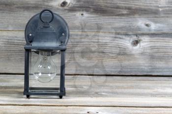 Horizontal image of old outdoor light on rustic wooden boards