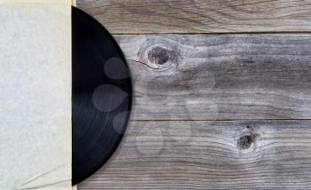 Old music record in original paper holder on vintage wood 
