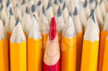 Close up front image of stacked pencils with focus on tip of red pencil in middle of the stack 