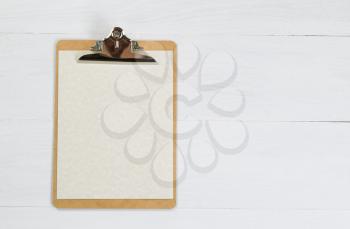 Blank clipboard with paper on white desktop.

