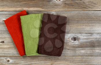 Colorful cleaning rags on rustic wooden boards. 