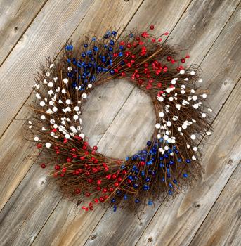 Wreath decorated for Independence Day on rustic wooden boards.