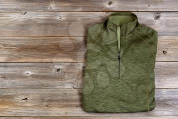 Green hiking shirt on rustic wooden boards. 