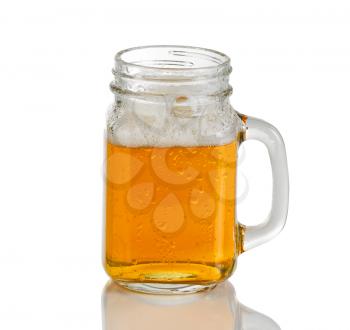 Cold reddish amber colored beer in jar glass. Isolated on white background with reflection. 