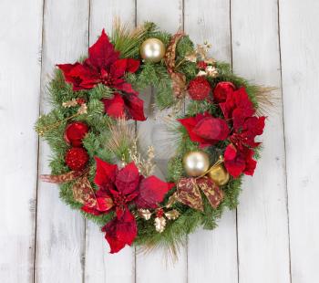 Traditional Christmas wreath on rustic white wood. Boards in vertical pattern.  