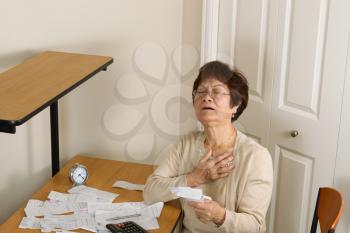 Senior woman feeling ill with her financial bills. In debt concept. 