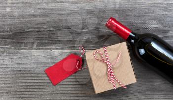 Fathers day gift box with red wine bottle on vintage wooden plank background