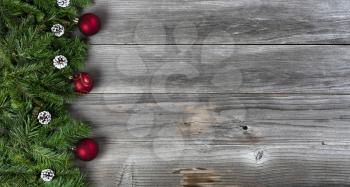 Merry Christmas and Happy New Year holiday concept with decorations on left side of rustic wooden boards