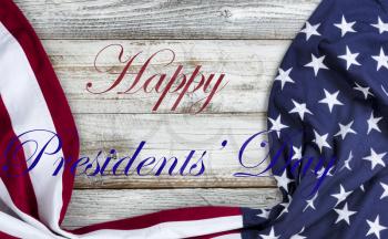 Happy Presidents Day text message with draped US flag on bottom of white rustic wood