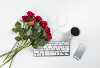 Lovely red roses on work desktop for a romance concept such as Valentines Day