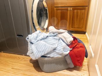 Close up of a full laundry basket with home washer in background 