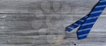 Blue striped necktie on weathered wooden planks for Happy Fathers Day concept 
