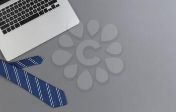 Fathers day concept with blue dress tie and laptop computer on a gray background in flat lay format