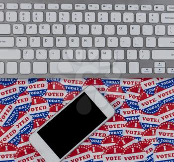Technology positioned on top of I voted today stickers background with United States national colors or red, white and blue 