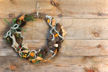 Green Christmas Wreath with Decorations on Wooden Background. Closeup.