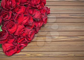 Colorful flower bouquet from red roses on wooden background. Closeup.