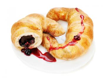 Fresh and tasty croissant with chocolate and raspberry jam on plate isolated on white background.