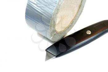 Roll of duct tape and knife isolated on white