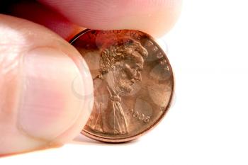 Fingers holding a penny isolated on white
