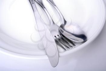 Macro shot of a white plate with utensils on it