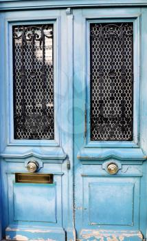 Close up of a grungy all weathered doors in a home´s entrance in Paris, France.