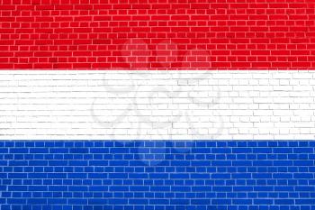 Flag of Netherlands on brick wall texture background. Dutch national flag.