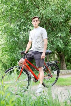 Young handsome bicyclist in a summer park
