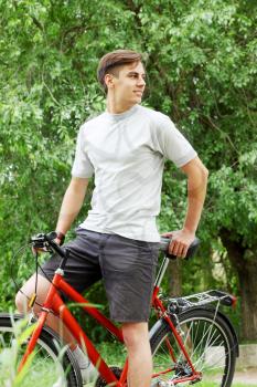 Young handsome bicyclist in a summer park