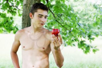 Adam with an apple in his hand under the tree