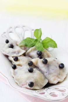 Hot dumplings with blueberries and butter and mint
