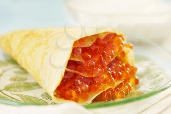 Ruddy pancake stuffed with red caviar, shrove