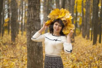 Girl in autumn park with maple leaves.