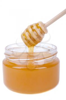 Honey dripping into a jar with a special spoon.