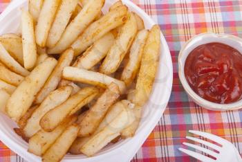 Fried potatoes in a plate on a tablecloth.