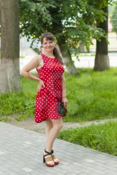 Young beautiful girl in a dress for a walk in the park.