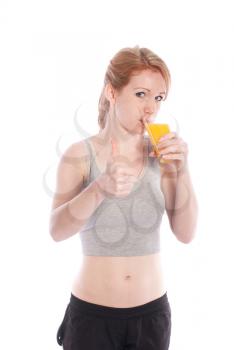 Athletic girl with a glass of juice and a thumbs up on a white background.