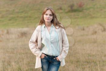 Beautiful girl with long hair posing in a meadow.
