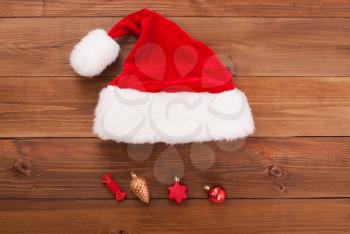 Santa hat with toys on wooden background.