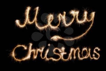 Merry Christmas . Inscription made sparklers on a dark background.