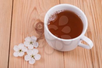 Tea and flower on a wooden background. View from above .