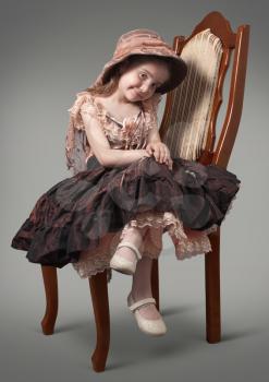 Little girl sitting on a chair a luxurious
