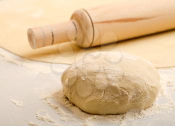 ball of dough and rolling pin over on the kitchen table