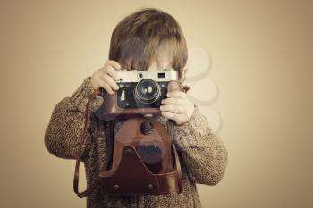 little boy taking pictures with old retro camera