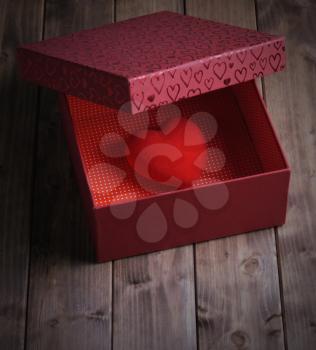 Heart in a gift box on an old wooden table, love concept