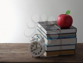 set of books with alarm and red Apple education concept