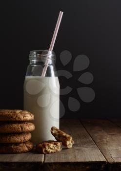 Homemade cookies and bottle of milk on table close up