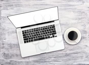 Top view of blank laptop and cup of coffee on a white  rustic wooden table. clipping path