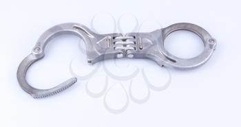Metal handcuffs isolated on a grey background